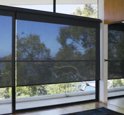 Solar roller shade in a living room preserving the outdoor view while blocking heat
