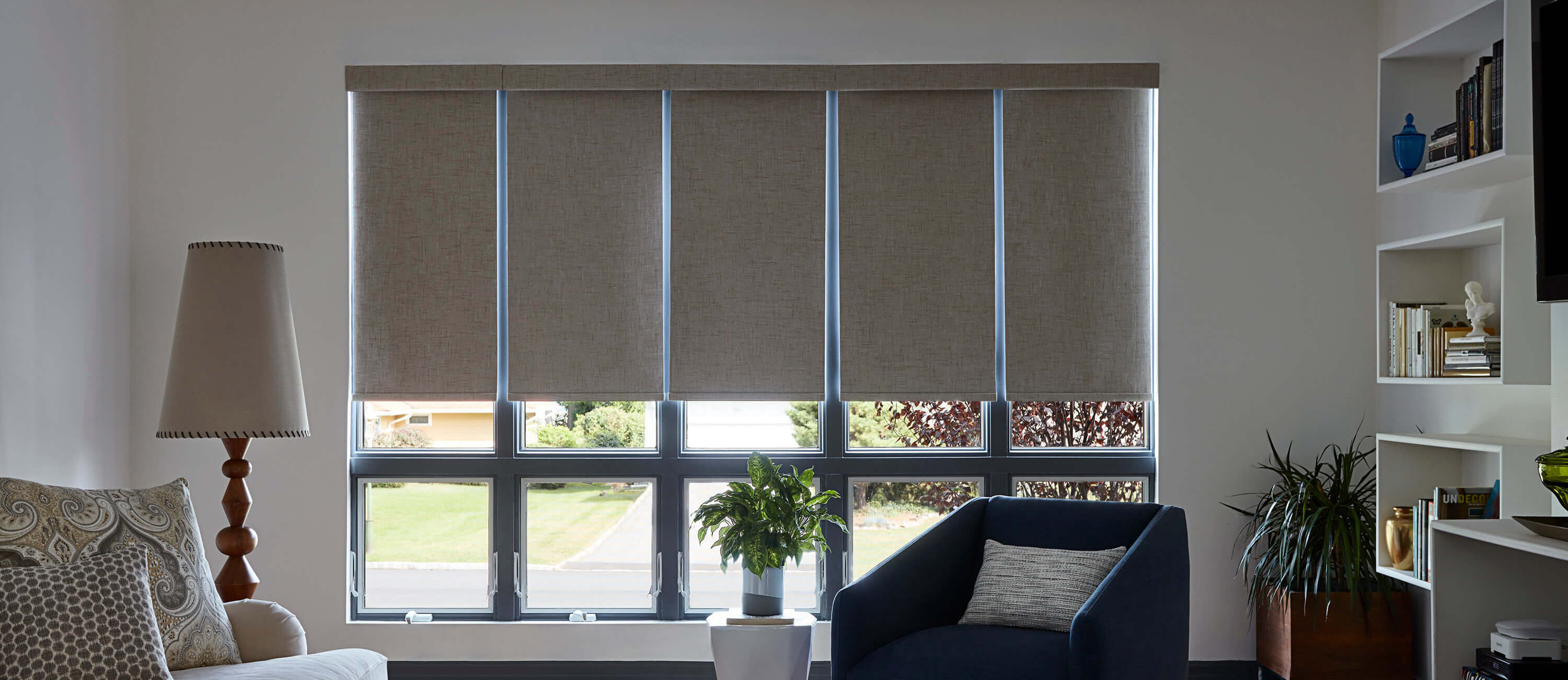 Neutral fabric roller shades across a wide living-room window — window treatments Big Brands Blinds supplies to Richmond, BC